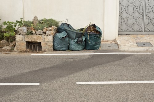 Workers loading construction debris into a skip.